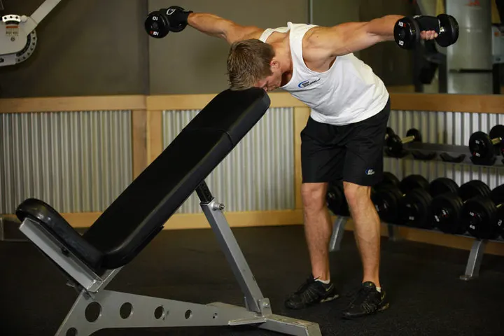 Bent Over Dumbbell Rear Delt Raise With Head On Bench — End position